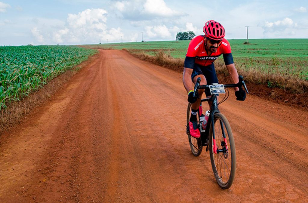 cilclista pedalando em rua de terra com uma bicicleta gravel